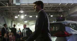 Prime Minister Justin Trudeau walks past a 2017 Chevrolet Volt electric vehicle at the Oshawa GM plant in June, 2016. Trudeau said today he has expressed his disappointment to the company over its decision to shut down production there late next year. (Chris Young/Canadian Press)